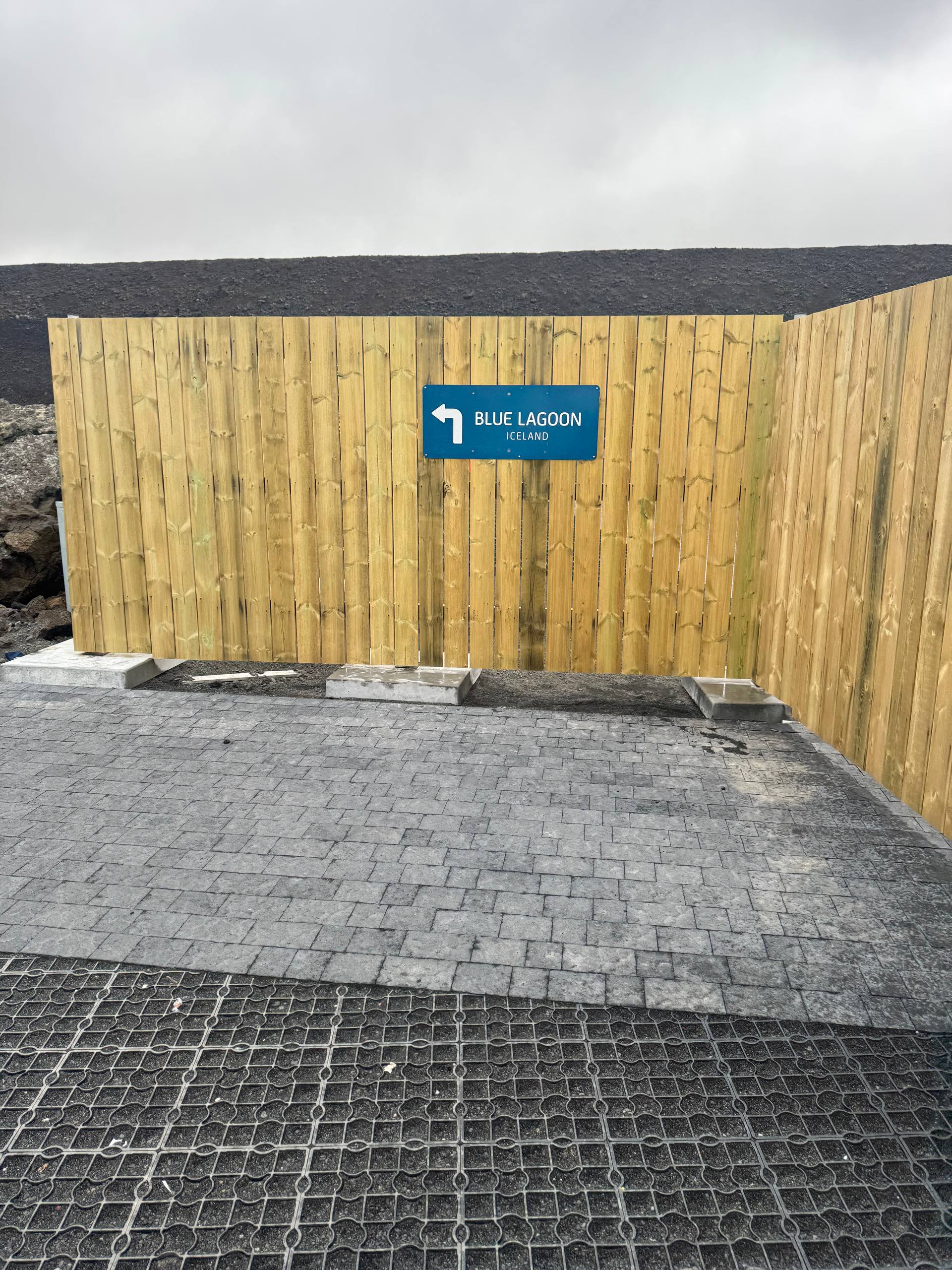 Sign pointing to Blue Lagoon Iceland surrounded by lava field terrain during a Day Trips From Reykjavik tour with our agency