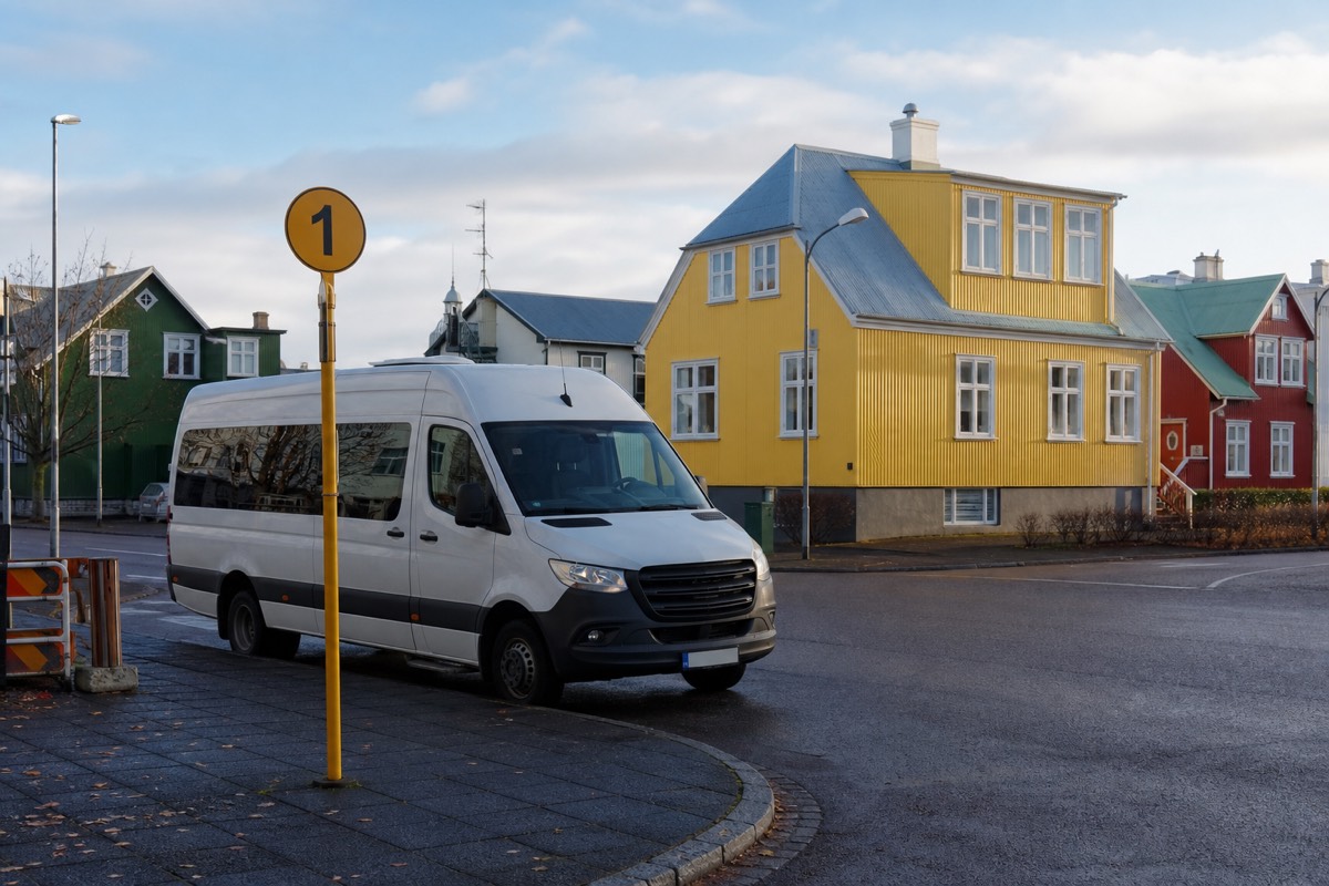 A tour coach waiting at a numbered pickup stop on a Reykjavik street at dawn