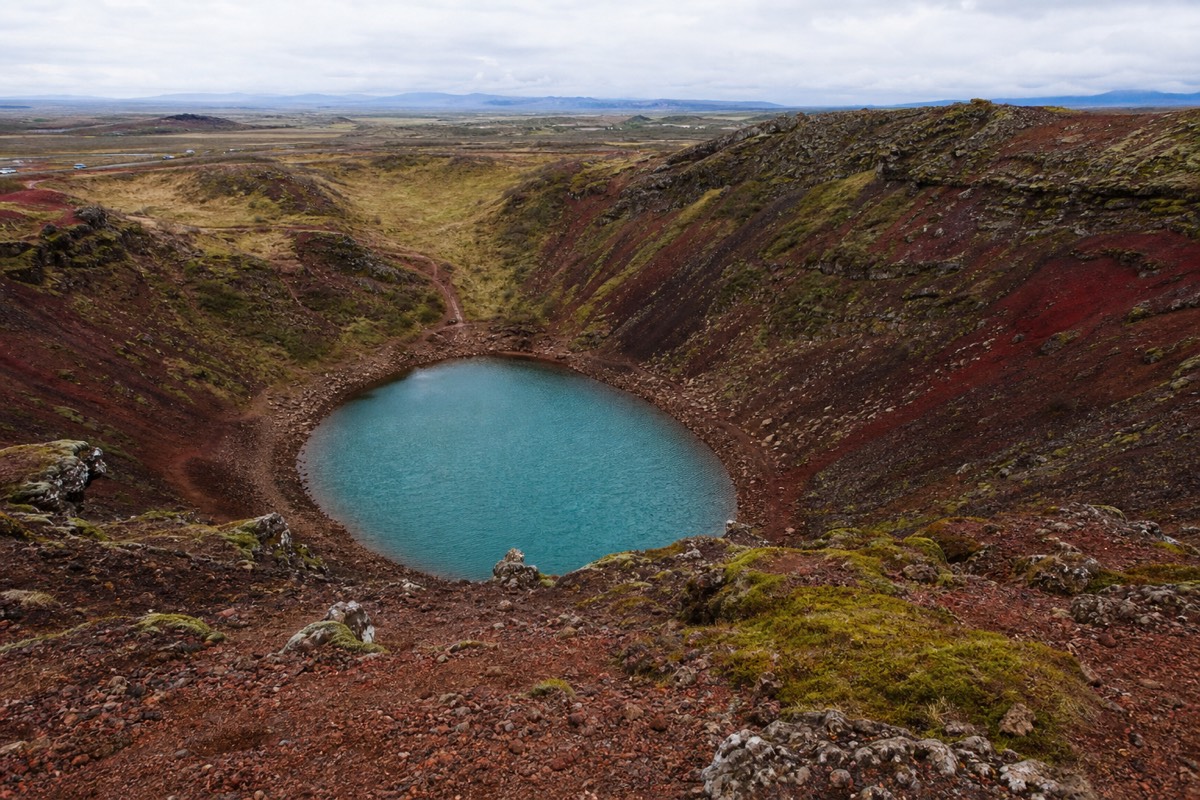 The red scoria walls and blue-green lake of Kerid crater in south Iceland