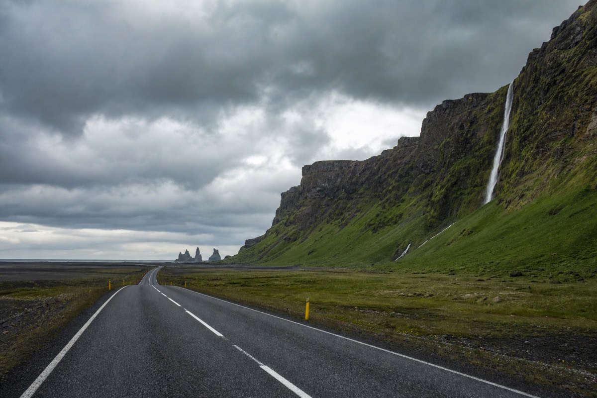 The Reynisdrangar sea stacks rising off the black coastline beside the village of Vik in south Iceland